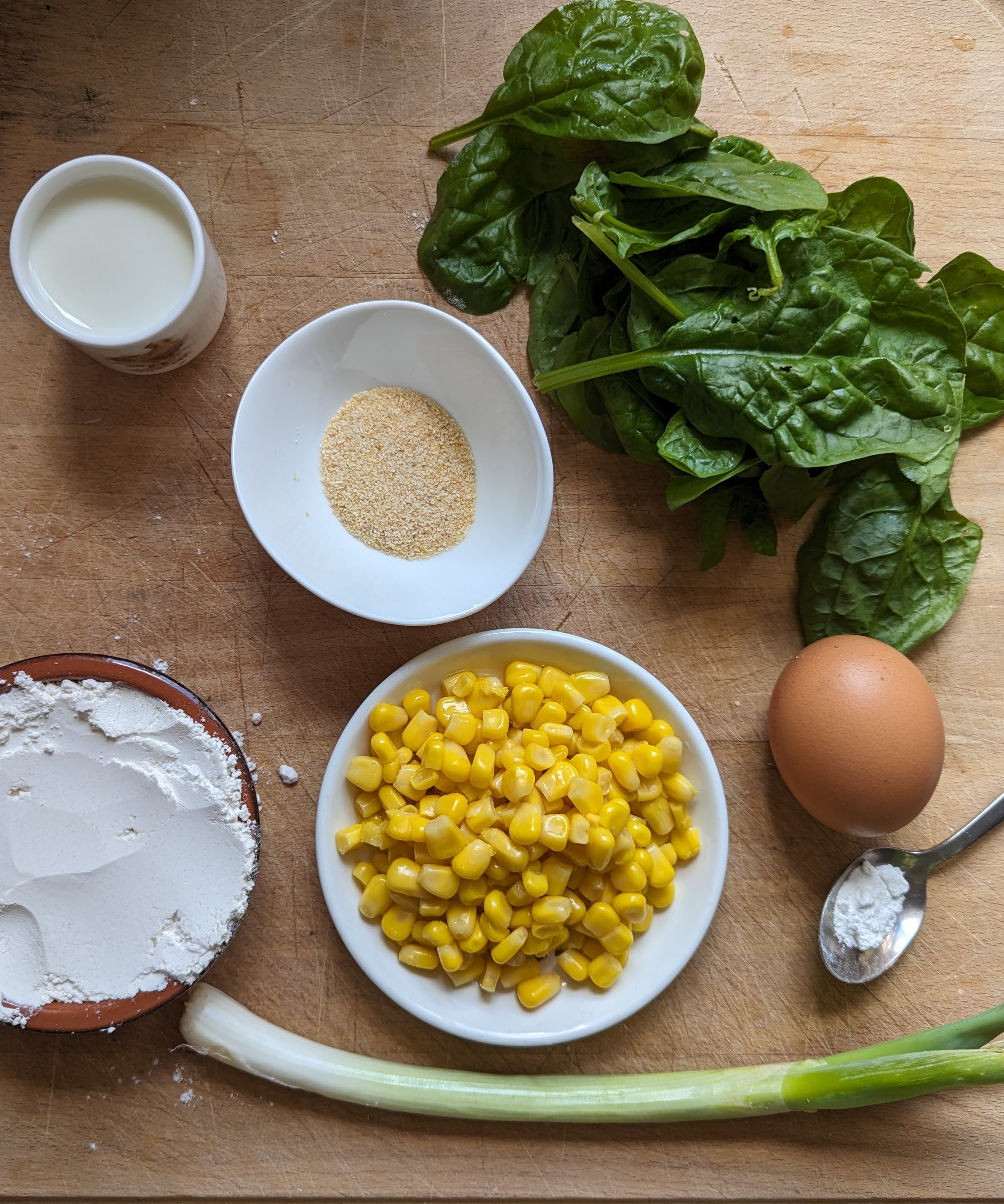 Ingredients for Spinach and Sweetcorn firtters placed on a chopping board